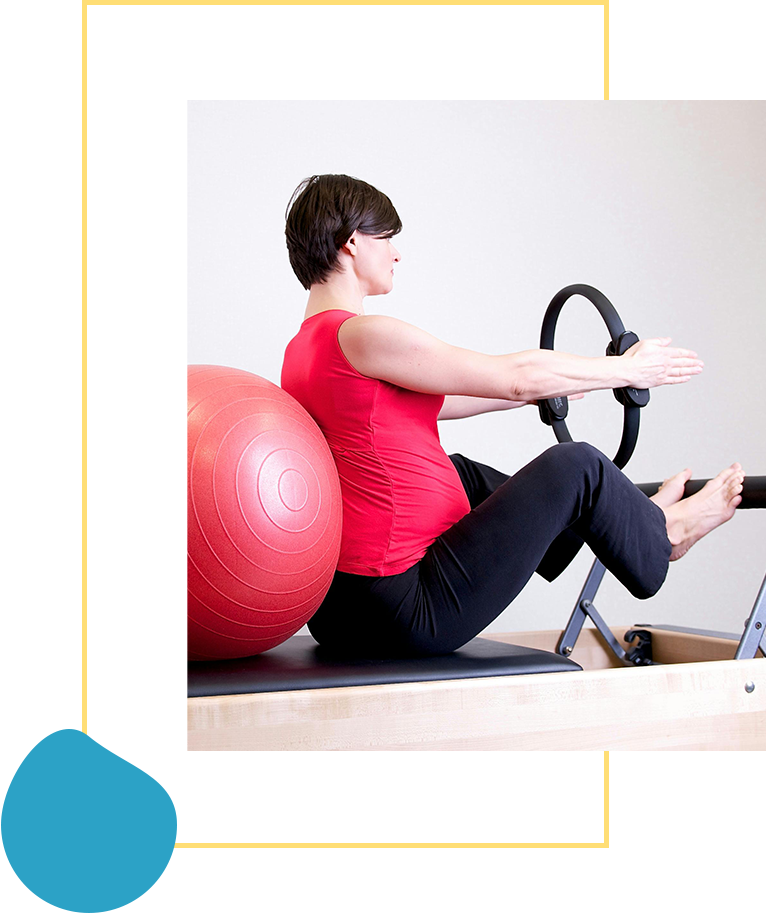 A woman is sitting on the floor with a ball and steering wheel.